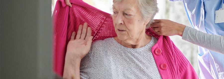 Elderly woman being assisted by a carer
